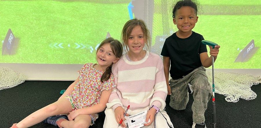 Three young golfers smiling at Golf House Academy