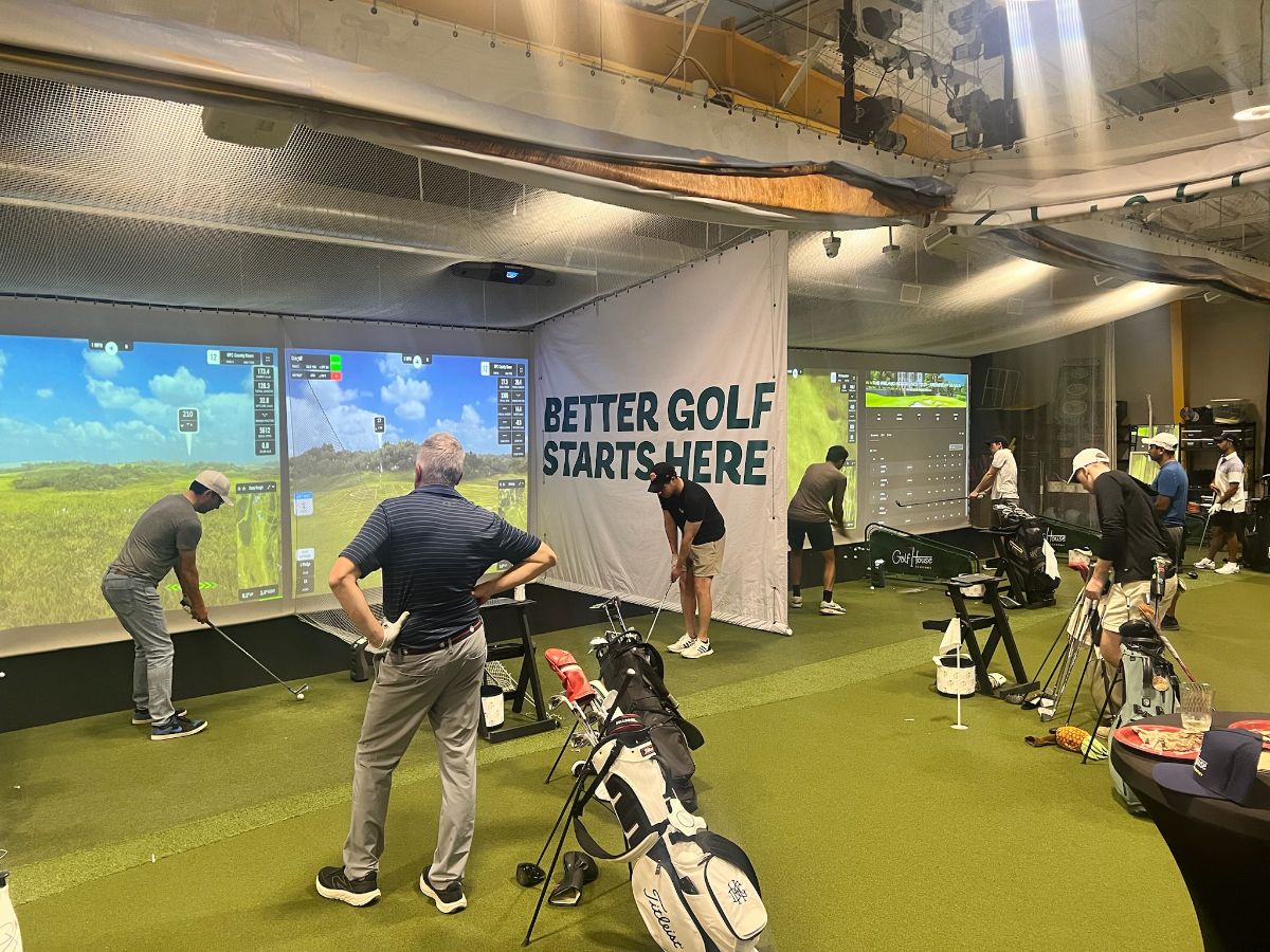 Golfers playing a Golf House Academy league night on indoor simulators in Atlanta