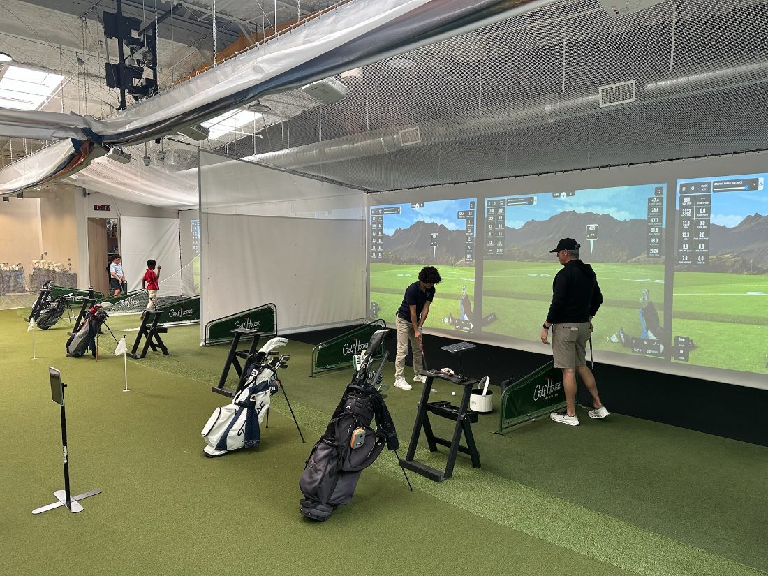 Golfer practicing in a Golf House Range bay